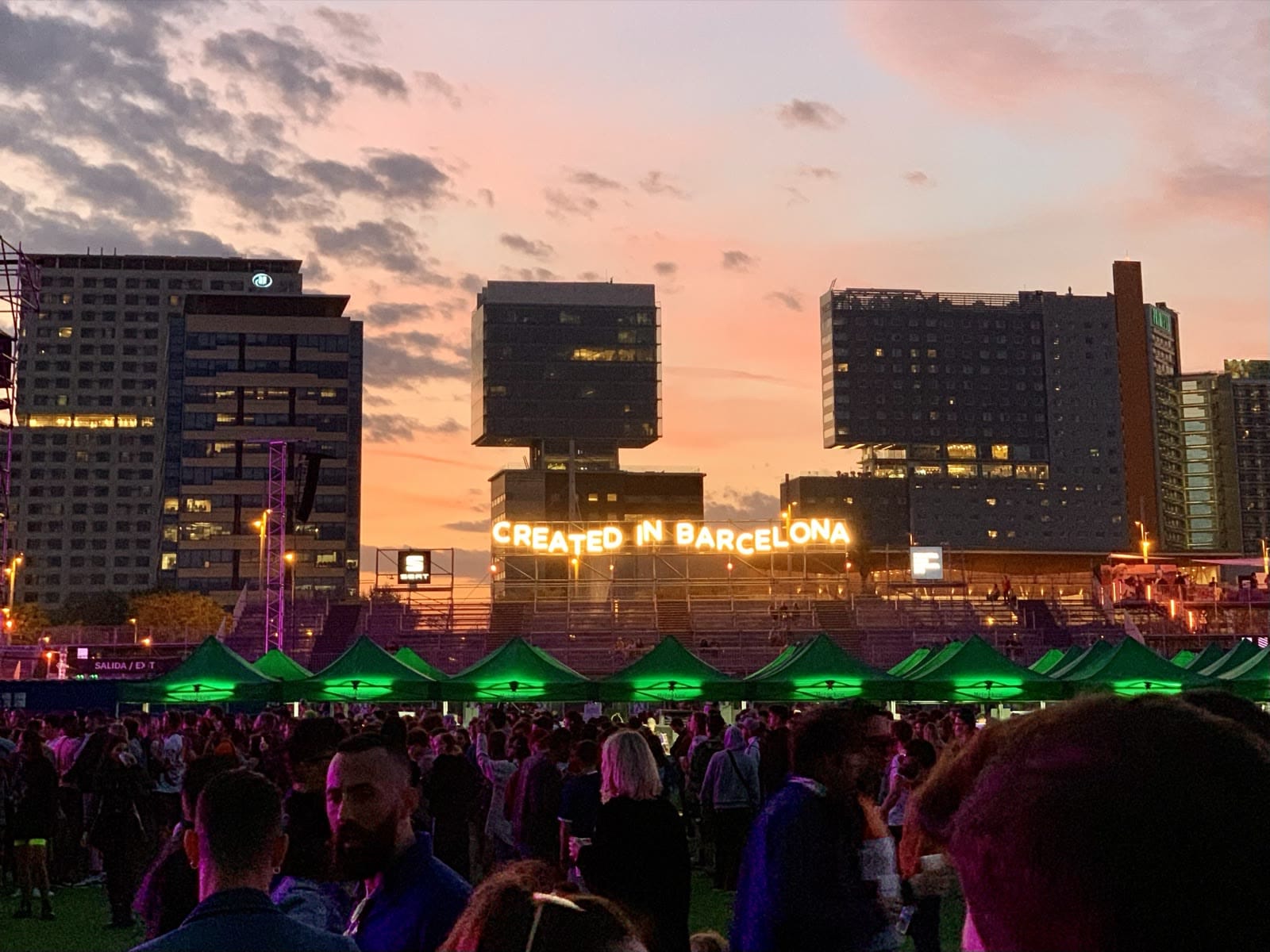 Festival crowd at sunset beneath an illuminated Created in Barcelona sign at Primavera Sound 2019