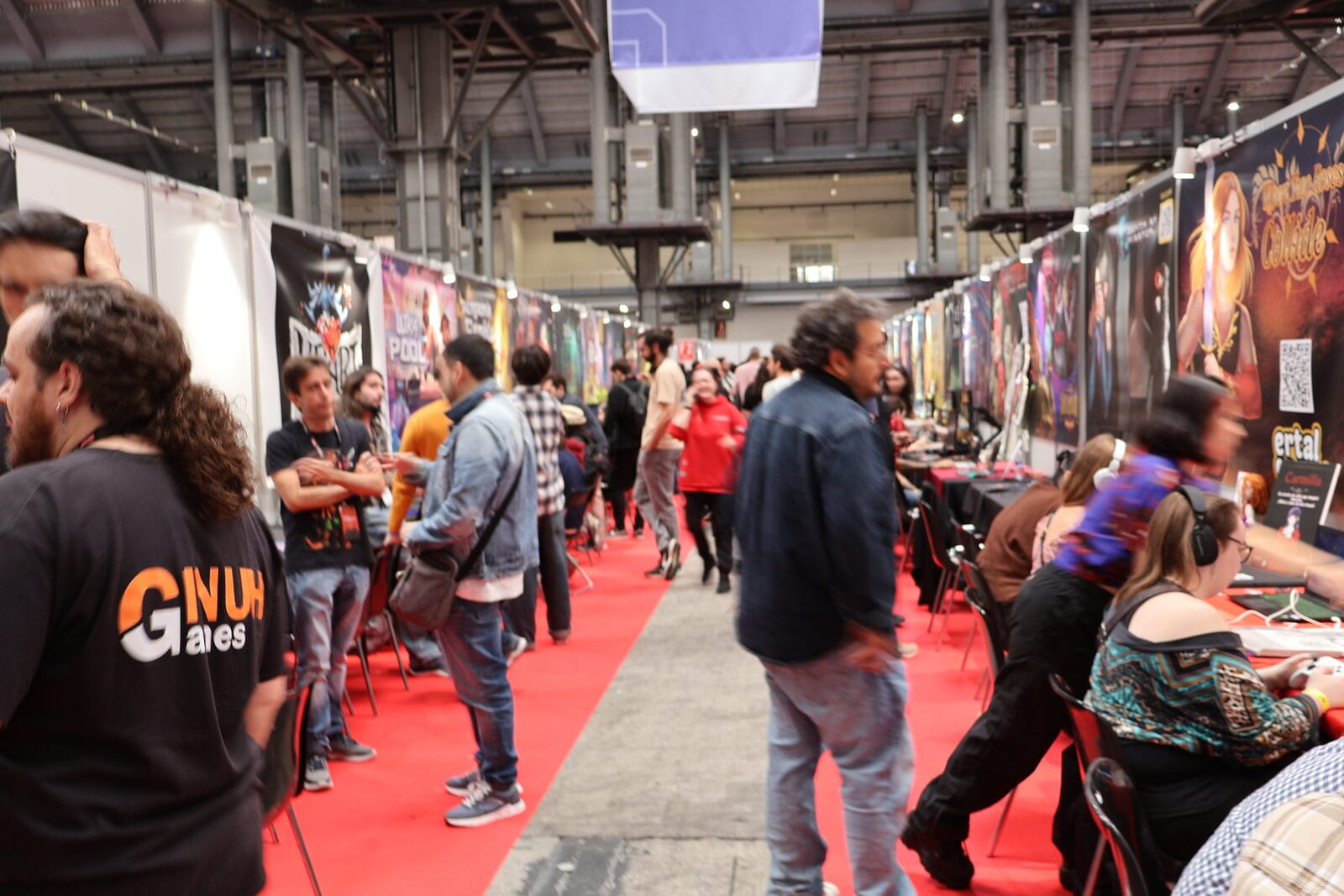 Visitors strolling down a row of stands run by independent game developers