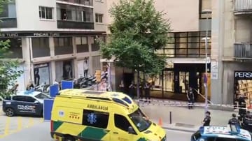 Police tape blocks off a street in Barcelona as officers investigate a crime scene.
