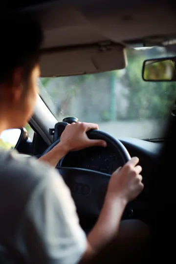 A learner driver sits in a driving school car on a Barcelona street during a practical lesson.