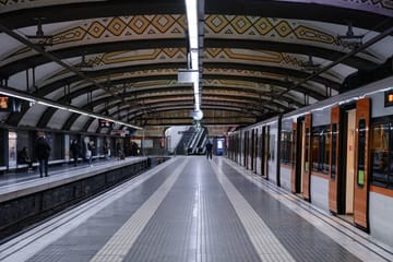 A Barcelona Metro train stopped beside a platform at an underground station in Barcelona.