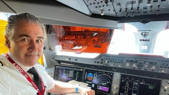 An Iberia commercial airliner flying over Barcelona.
