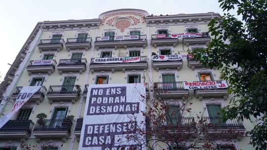 Barcelona's Eixample district with residential buildings and a street.