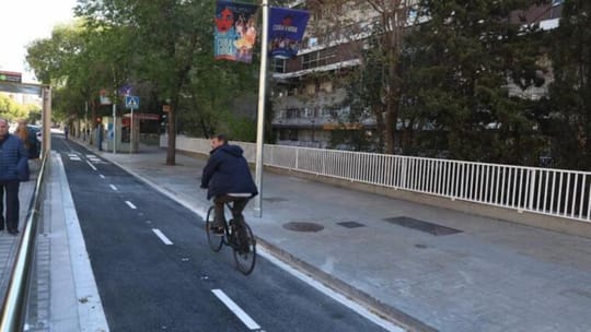 Cyclists riding along Travessera de les Corts bike lane in Barcelona's Les Corts district