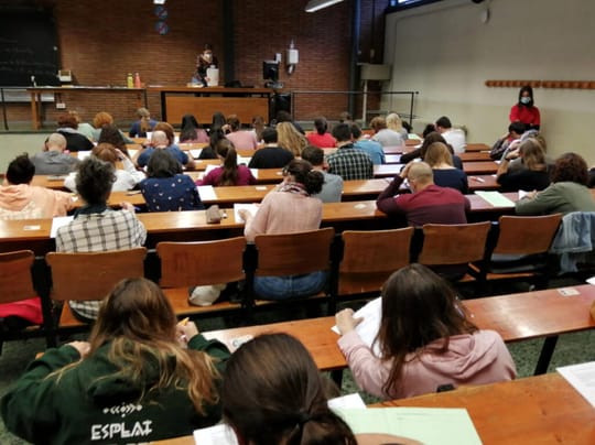 Candidates seated at desks during a written Catalan language examination.