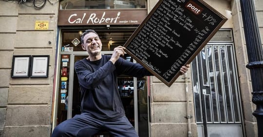Exterior view of Cal Robert restaurant in El Raval, Barcelona, with its sign and a glimpse of the street.