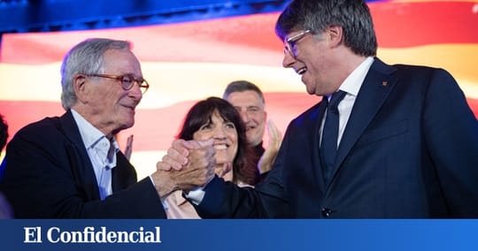 Carles Puigdemont, former Catalan president, speaking at a political event with Junts per Catalunya party branding in the bac