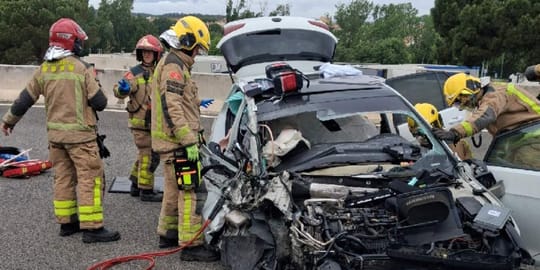 Emergency services vehicles, including fire engines and ambulances, attending a car and coach collision on a motorway hard sh