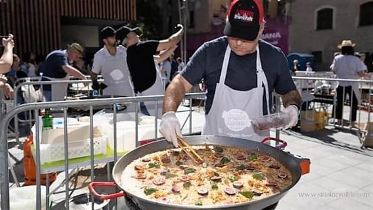 Chefs judging a paella competition on La Rambla, with participants cooking paellas in large pans.