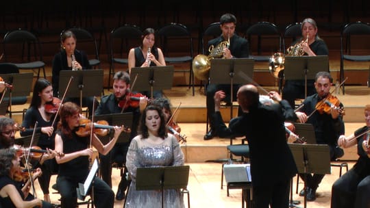 Soprano Adriana González performing on stage at L'Auditori during the Concert for Peace, with an orchestra and choir behind h