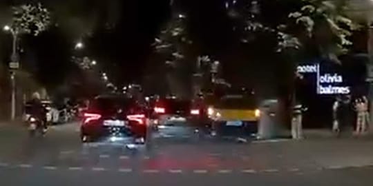 Damaged taxi door after a hit-and-run incident on a busy Barcelona street at night