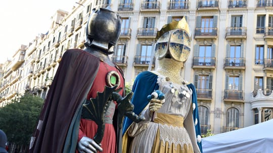 People dressed in period costumes at the Fira Modernista on a Barcelona street with Modernist buildings.