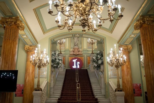 A historical photo of the Gran Teatre del Liceu in Barcelona, showing its grand facade and surrounding street.