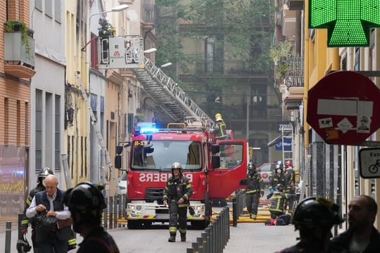 Emergency services vehicles and personnel at the scene of a residential building incident in Barcelona's Poblenou district.