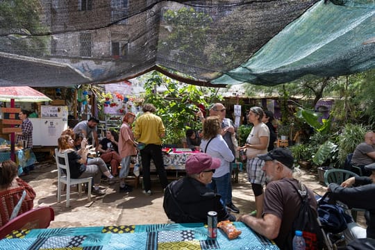 People gathered at Ágora Juan Andrés Benítez, a community-managed public space in Barcelona's Raval district, with green area