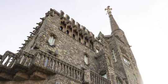 Torre Bellesguard, a unique Modernist castle-like building by Antoni Gaudí, stands against a blue sky in Barcelona.