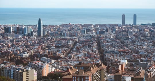 Barcelona's Poble-sec neighbourhood with residential buildings and Montjuïc mountain in the background.