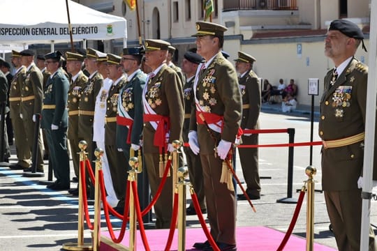 Civilians in a military courtyard raise their right hands to swear allegiance to the Spanish flag, held by soldiers.