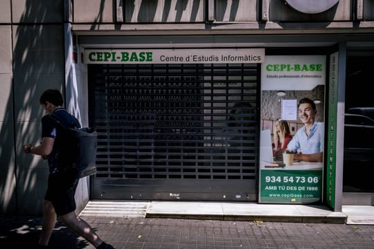 Students outside a closed Cepi-Base academy building on Balmes Street in Barcelona, seeking information after its sudden clos