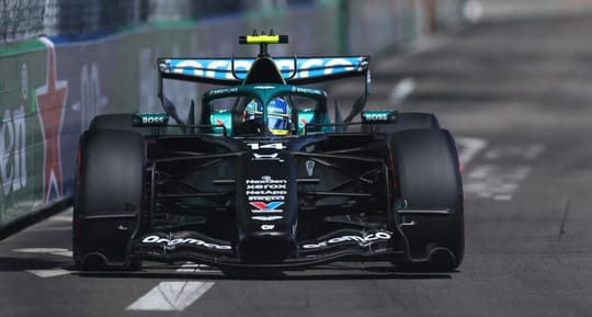 Fernando Alonso driving an Aston Martin Formula 1 car on the Circuit de Barcelona-Catalunya track.