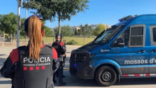 Police officers conducting a search or patrol during a large-scale operation in a Barcelona street.