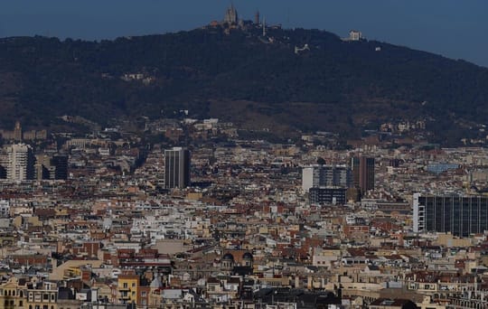 A street sign for Plaça Virrei Amat in Barcelona, with the city's distinctive Eixample architecture in the background.