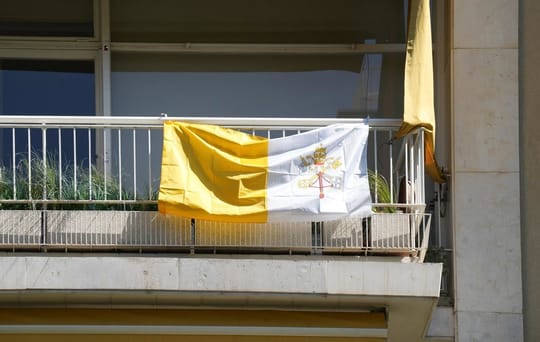 Sagrada Familia with a Catalan flag on its tower, representing the request for Catalan prayer.