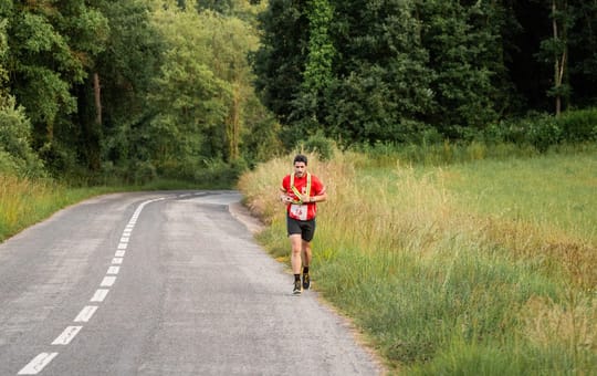 Ultra-runner traversing a mountain trail with the Catalan Pyrenees in the background