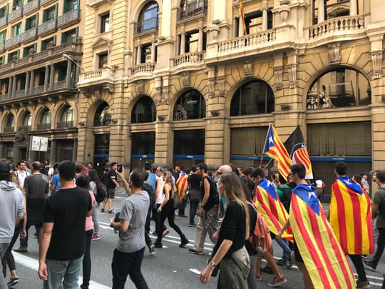 A crowd of demonstrators carrying Catalan independence flags during a public gathering in central Barcelona.