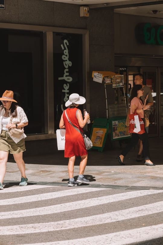 Two women shelter from extreme heat on a street in Malaga during Spain's summer heatwave.