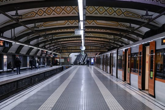 A Barcelona Metro train stopped beside a platform at an underground station in Barcelona.