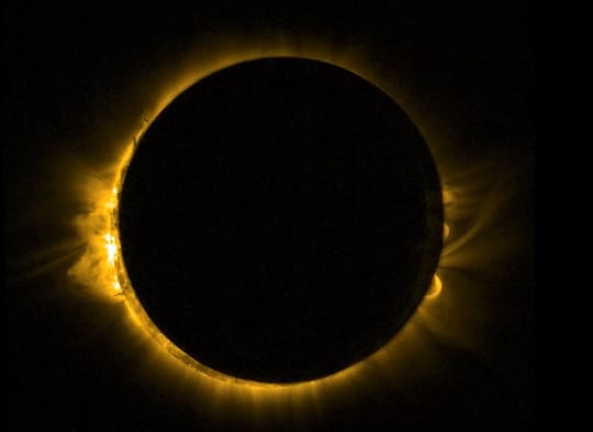 People wearing certified eclipse glasses look towards the Sun during a solar eclipse in Barcelona.