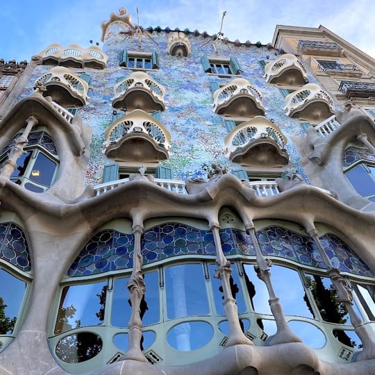 A close-up view of artisanal chocolate replicas of Gaudí's architectural details, arranged in a branded box, photographed in Barcelona.