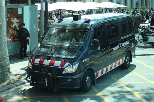 Police officers from the Mossos d'Esquadra standing beside an impounded vehicle with Polish licence plates at Terminal 1 of Barcelona-El Prat Airport.