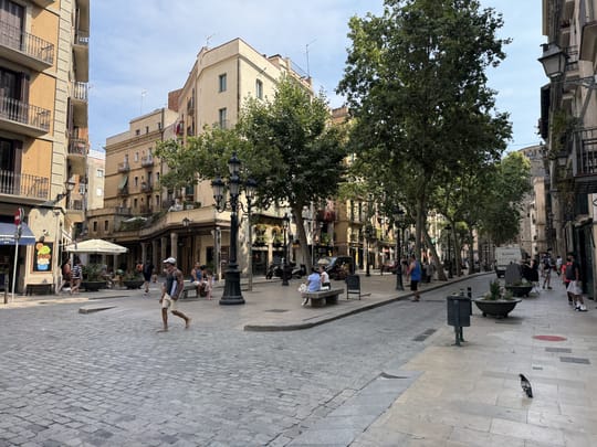 Crowds gather at Pla de Palau during a previous edition of Born Street Food, with food stalls, string lights, and people dining outdoors in Barcelona's historic El Born district.