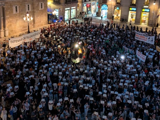 A city street filled with demonstrators holding banners during a housing rights protest in central Spain.