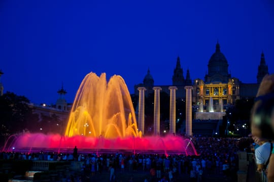 The Magic Fountain of Montjuïc at night, illuminated with colourful lights and water jets during a choreographed show.