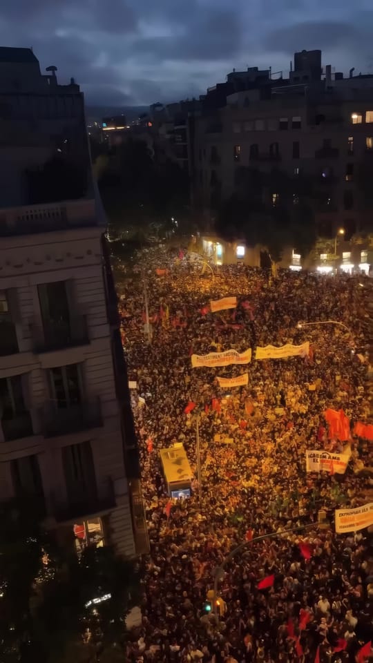 Housing protesters march through central Barcelona from Plaça Universitat carrying banners and a floral wreath for Olga and Maricarmen.