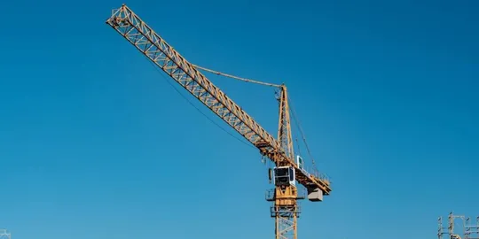 Emergency services personnel on a crane basket rescuing a man from a construction crane in Barcelona.