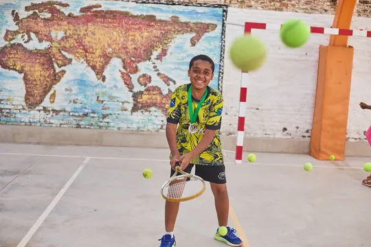 Young people hold tennis racquets on court at a Fundació Tennis Barcelona training session.