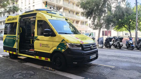 Ambulance parked outside a new emergency services base in Torre Baró, Barcelona, with residential buildings in the background