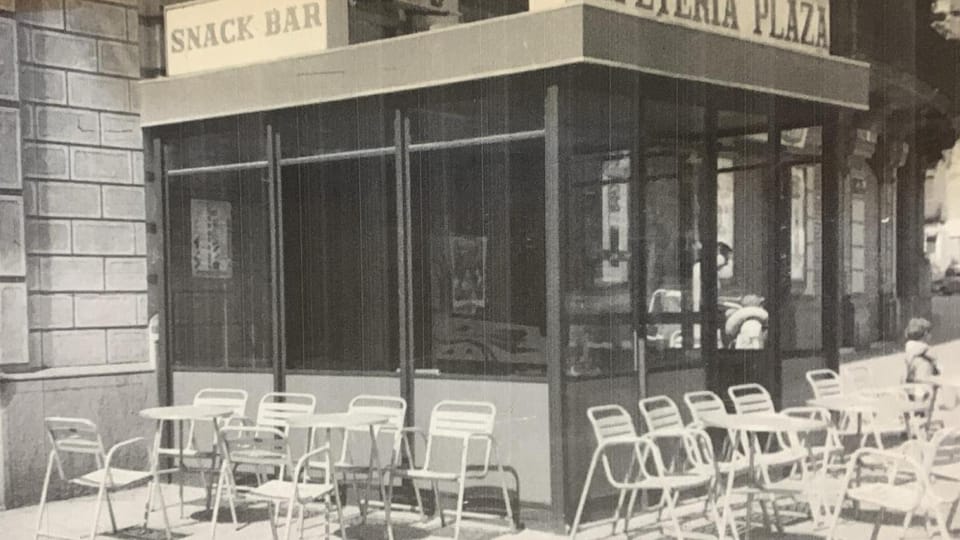 Exterior view of Bar La Plaza on Plaça Tetuán in Barcelona, showing its historic facade and a small terrace.