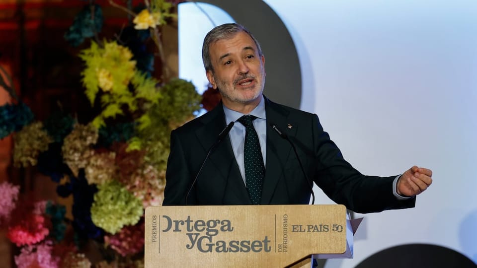 Barcelona Mayor Jaume Collboni speaking at a podium in a grand hall, with official seals and flags visible in the background.