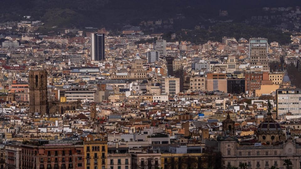 A panoramic view of Barcelona's skyline with modern buildings and the Mediterranean Sea in the background, symbolising econom