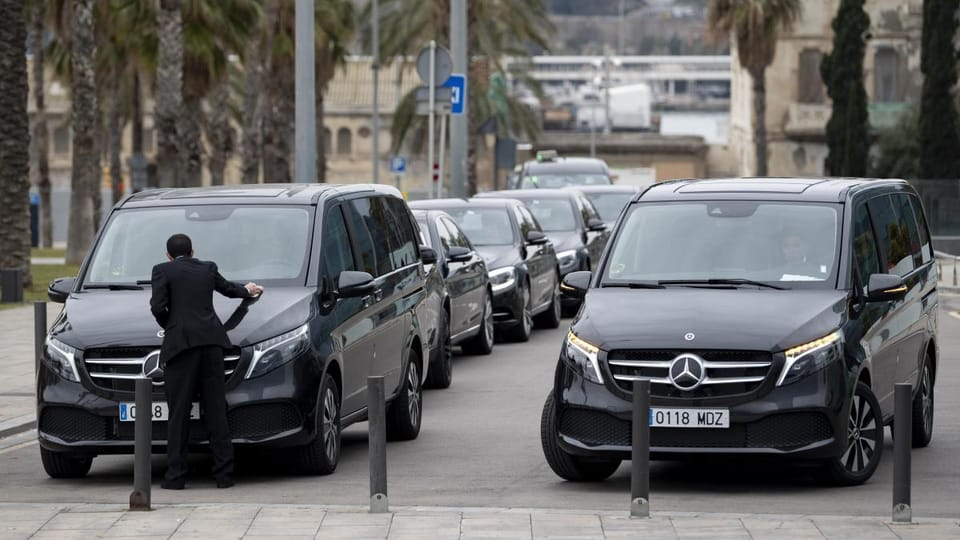 A high-end Mercedes-Benz VTC vehicle parked on a Barcelona street, with a blurred city background.