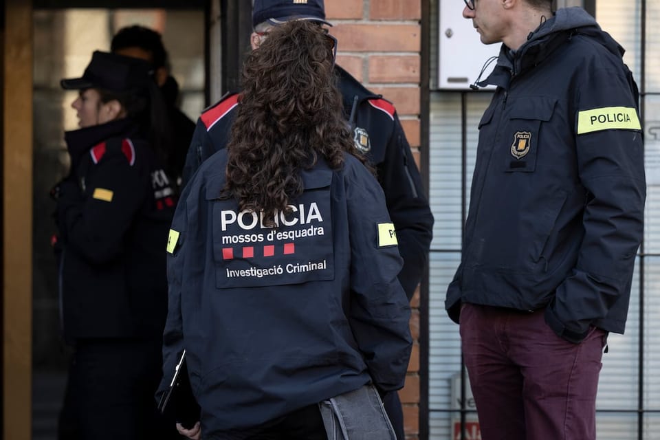 Police tape and emergency vehicles at a crime scene in a residential street in Esplugues de Llobregat.