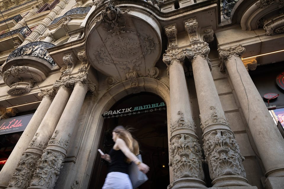The facade of Hotel Praktik at Rambla de Catalunya 27 in Barcelona, featuring an ornate architectural style and a street-leve