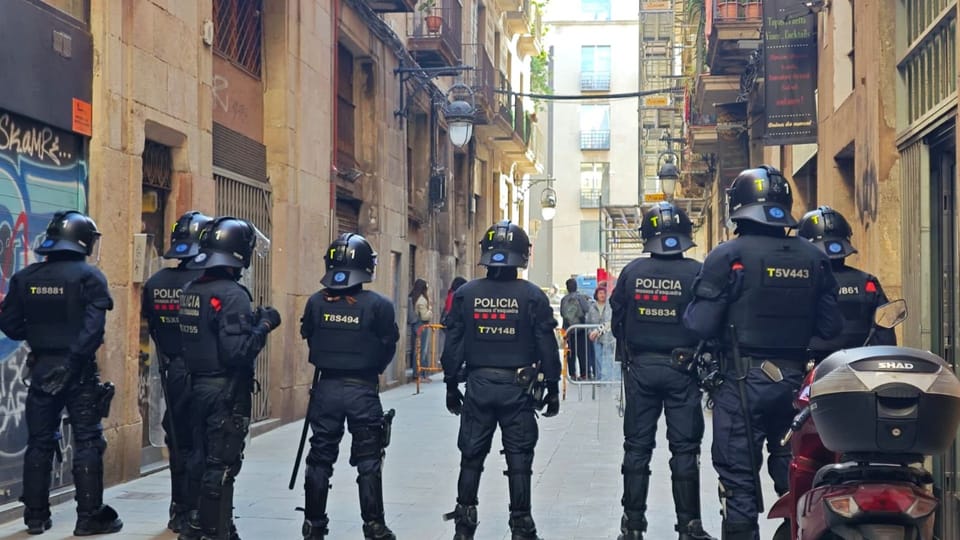 Protesters holding signs outside a building in Barcelona's El Raval district, demonstrating against an eviction.