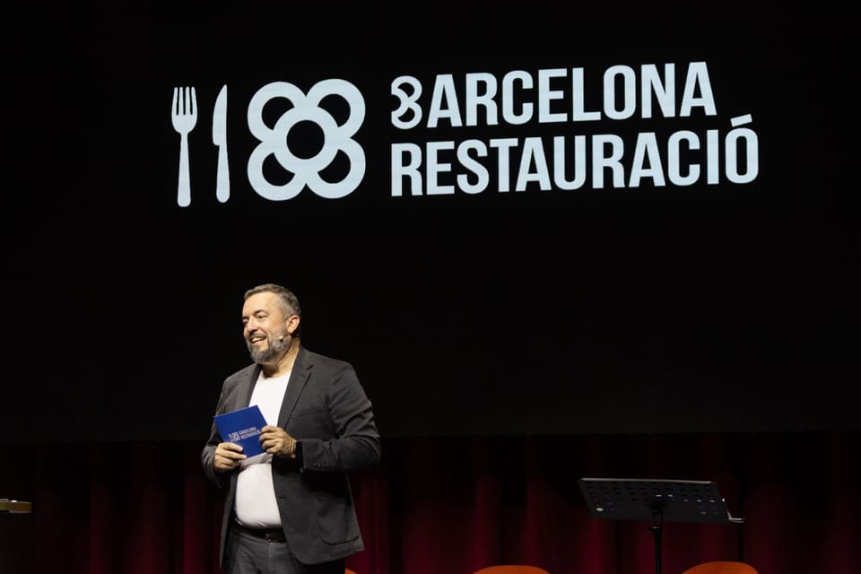 Salva Vendrell, president of Barcelona Restauració, speaking at a podium with Junts per Catalunya branding.