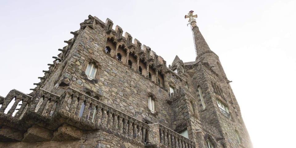 Torre Bellesguard, a unique Modernist castle-like building by Antoni Gaudí, stands against a blue sky in Barcelona.